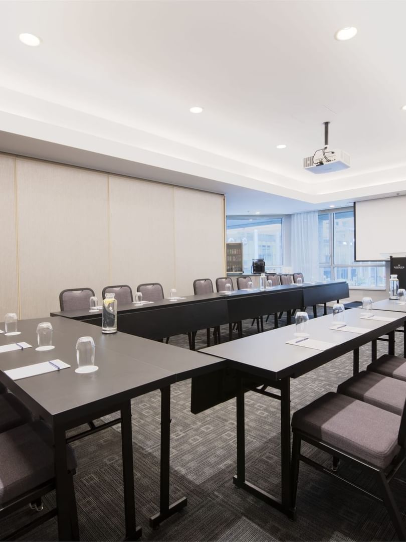 U-shaped table setup with chairs facing the projector screen in Salon René-Lévesque at Warwick Le Crystal Montreal