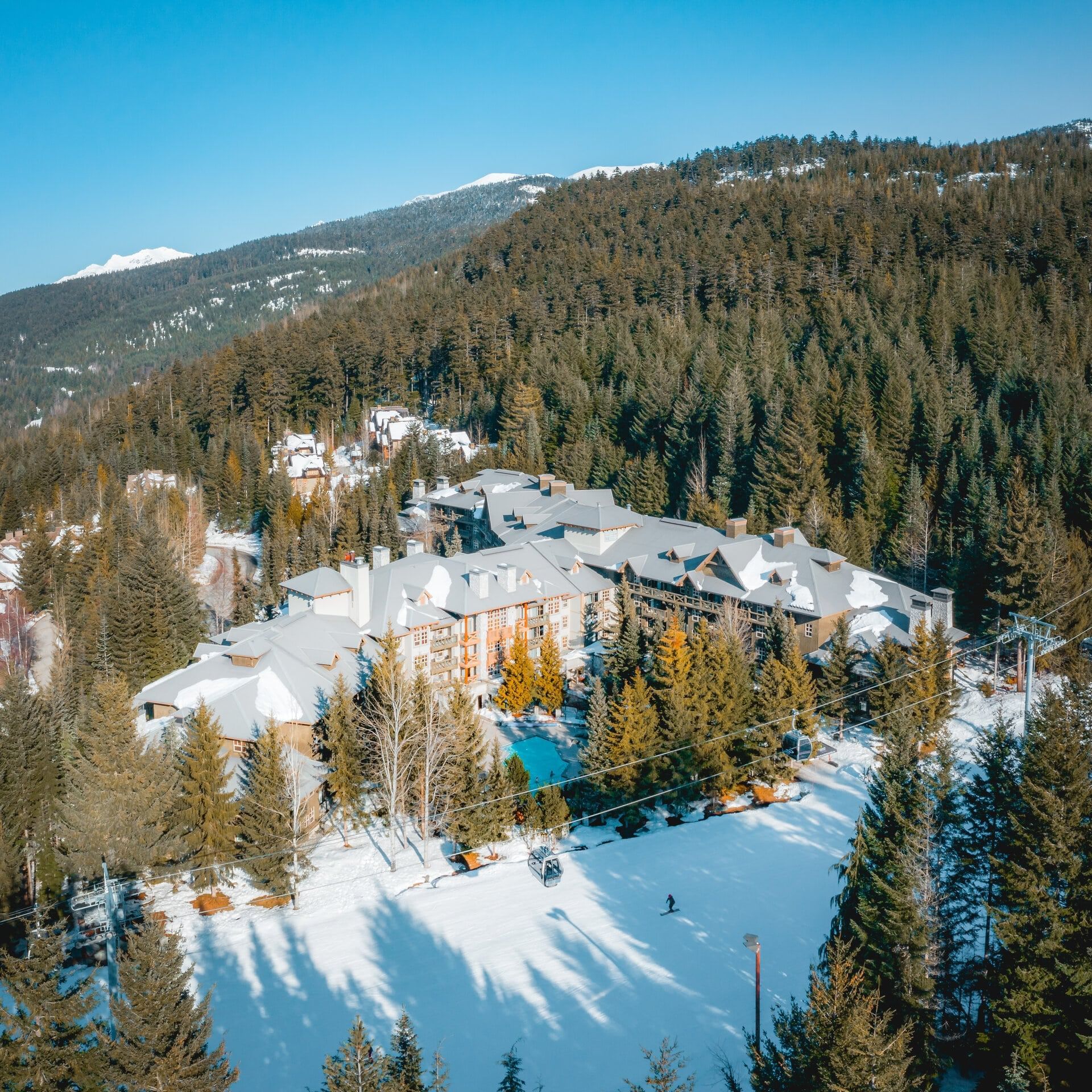 Aerial view of Blackcomb Springs Suites & outdoor pool with lush greenery 