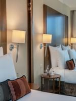 Chambre élégante dotée d'une literie luxueuse et offrant une vue sur la terrasse au Warwick Geneva à Genève.