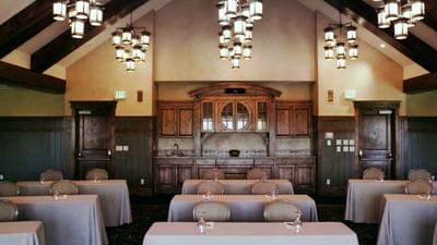 The classroom setup with a wooden cabinet and elegant chandeliers in the Aspen Room at Hotel Park City Autograph Collection