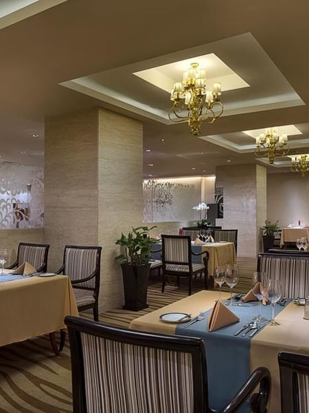 Dining tables arranged in Rainbow Room Western Restaurant at Celebrity International Grand Hotel