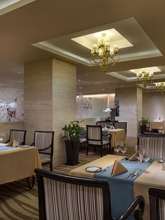 Dining tables arranged in Rainbow Room Western Restaurant at Celebrity International Grand Hotel