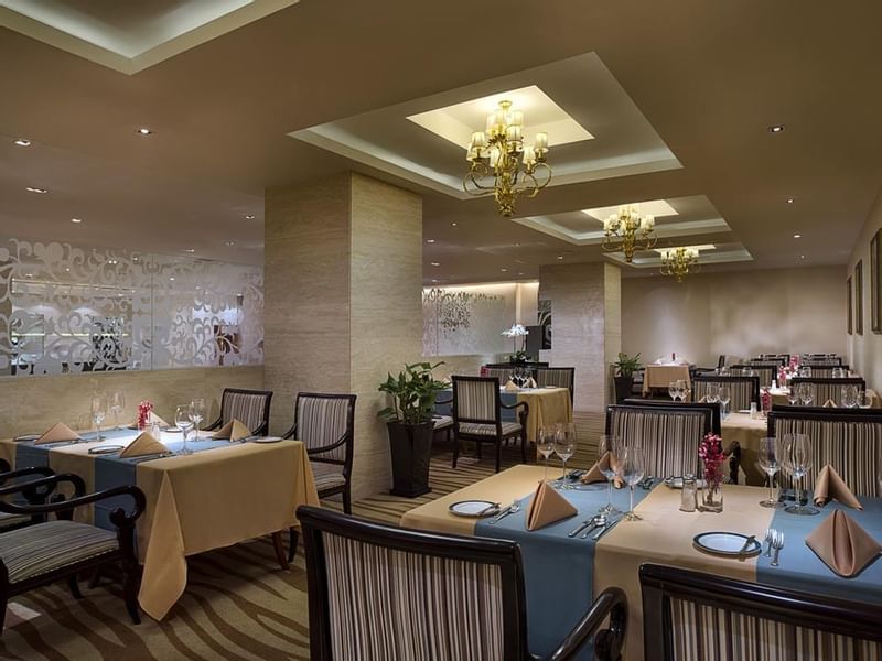 Dining tables arranged in Rainbow Room Western Restaurant at Celebrity International Grand Hotel