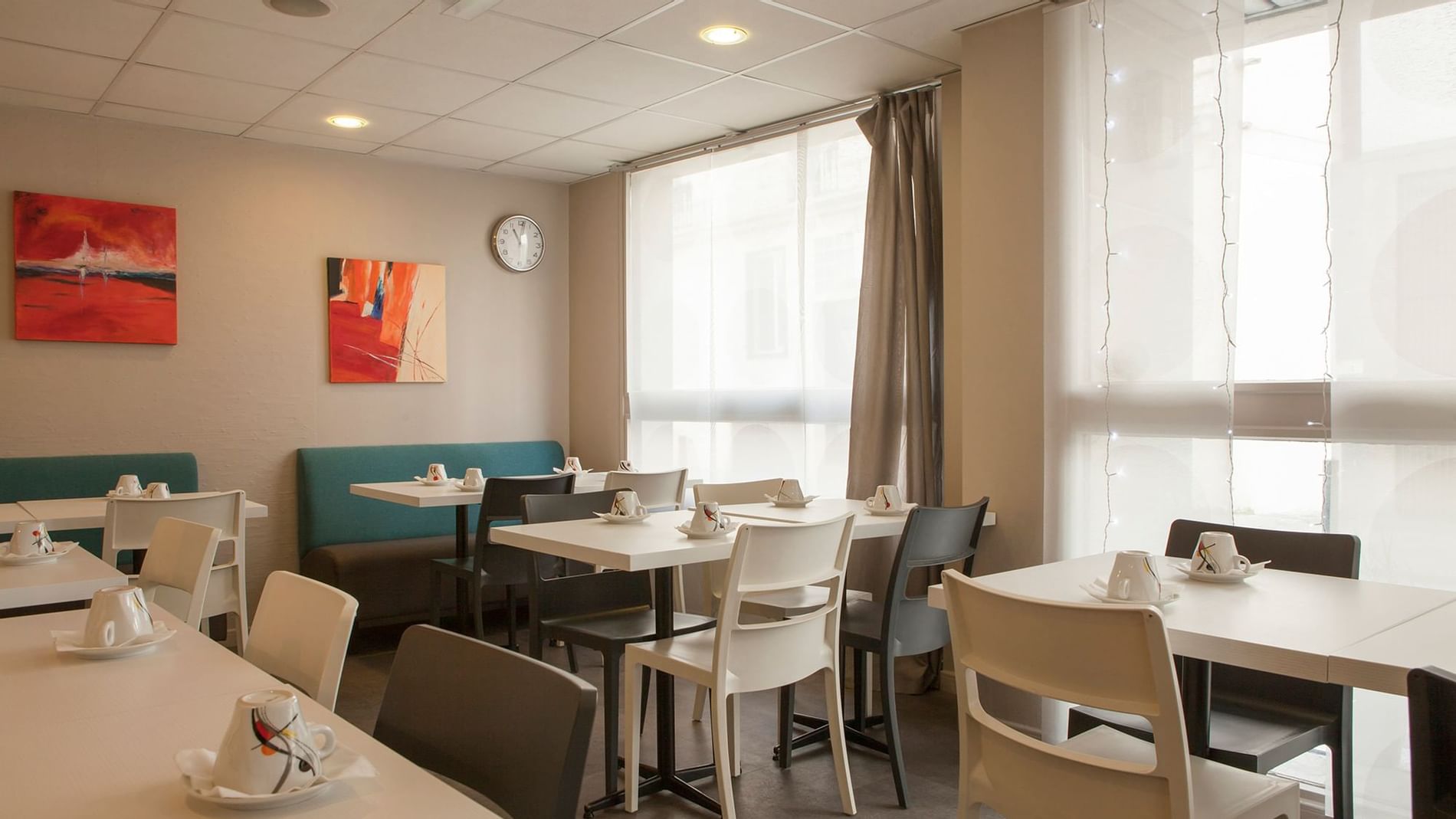 Arranged chairs & tables with tea cups at The Originals Hotels