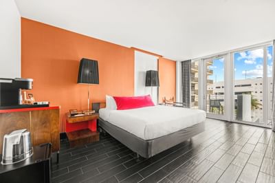 King bed with nightstands by the balcony window in King Suite with Balcony ADA at Fairwind Hotel Miami