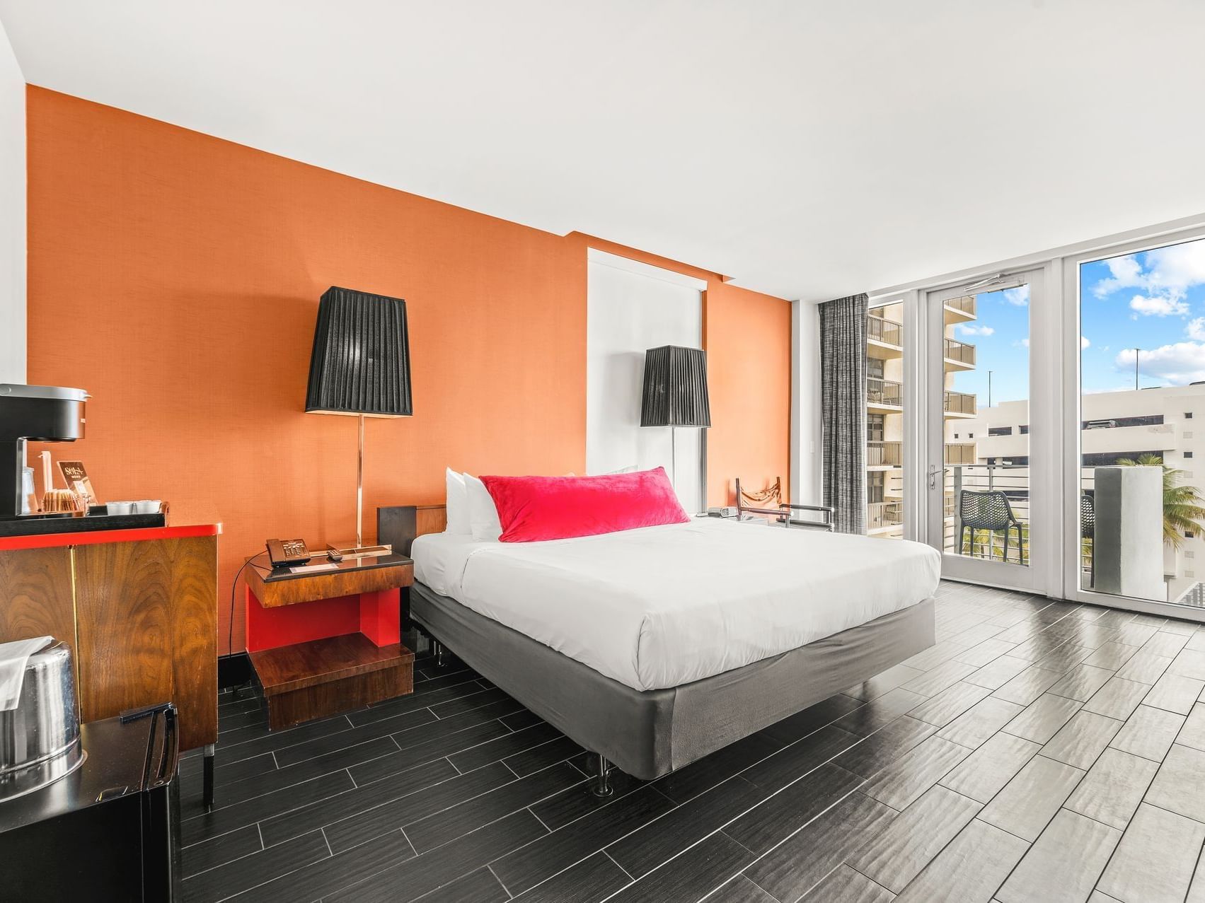 King bed with nightstands by the balcony window in King Suite with Balcony at Fairwind Hotel Miami