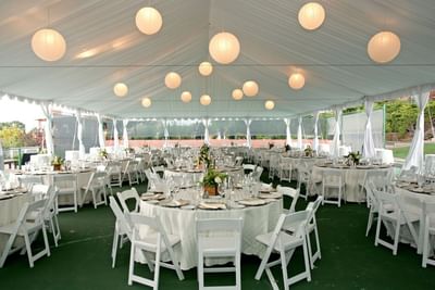 Outdoor wedding reception tent at Hilton Santa Fe Buffalo Thunder with  white tables, chairs, and hanging paper lanterns