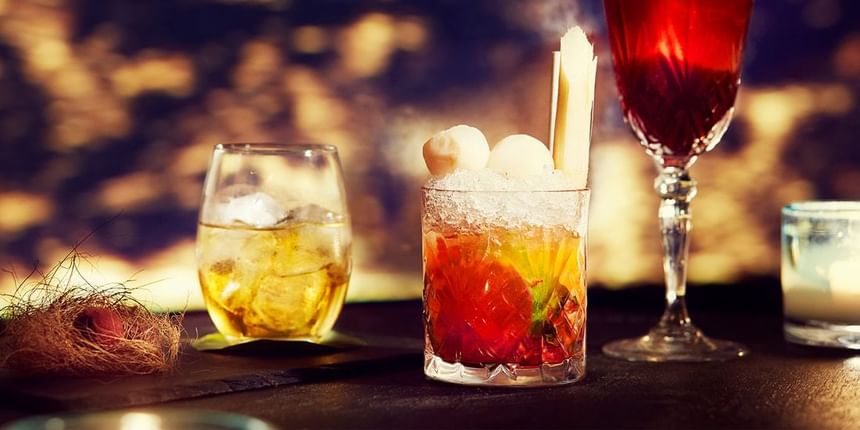 Three stylish cocktails on a black bar counter in the 2 Lam Son Bar at Park Hyatt Saigon