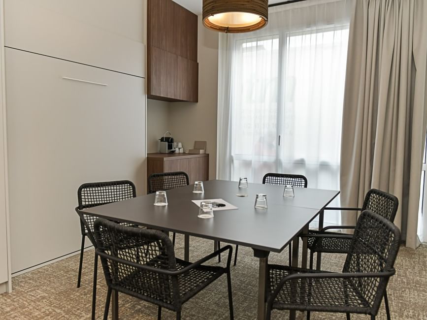 Salle de réunion élégante avec table et chaises au Hôtel Rivella.