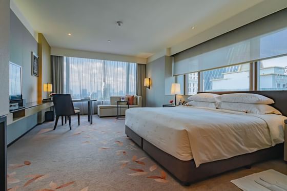 King bed in Deluxe Corner room at The Okura Prestige Bangkok