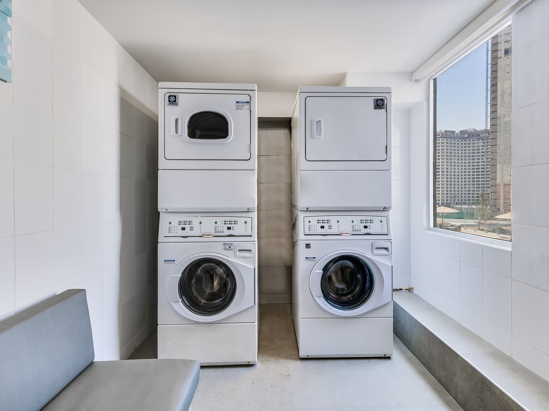 A laundry room with a stacked washer and dryer at One Hotels