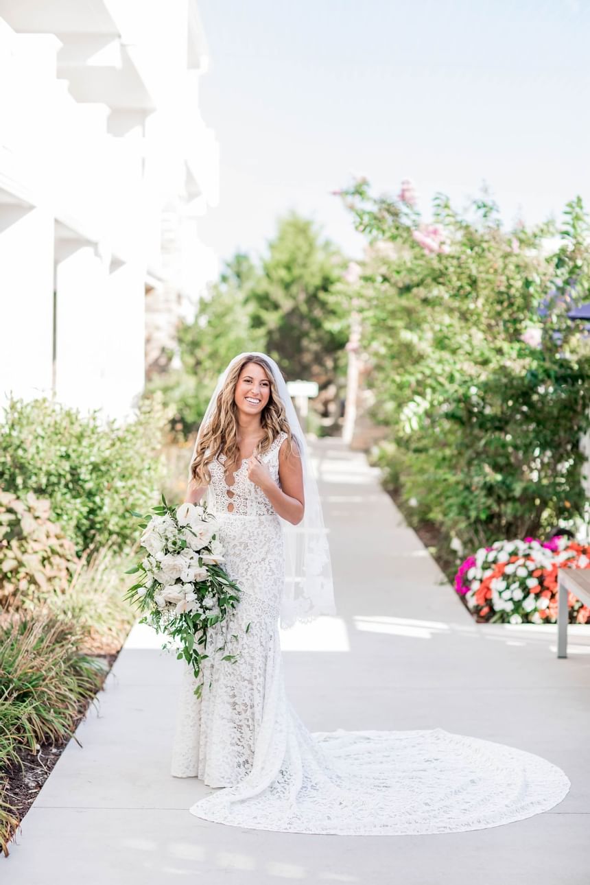 A bride poses for a photo with her bouquet in the aisle of our Avalon wedding venue