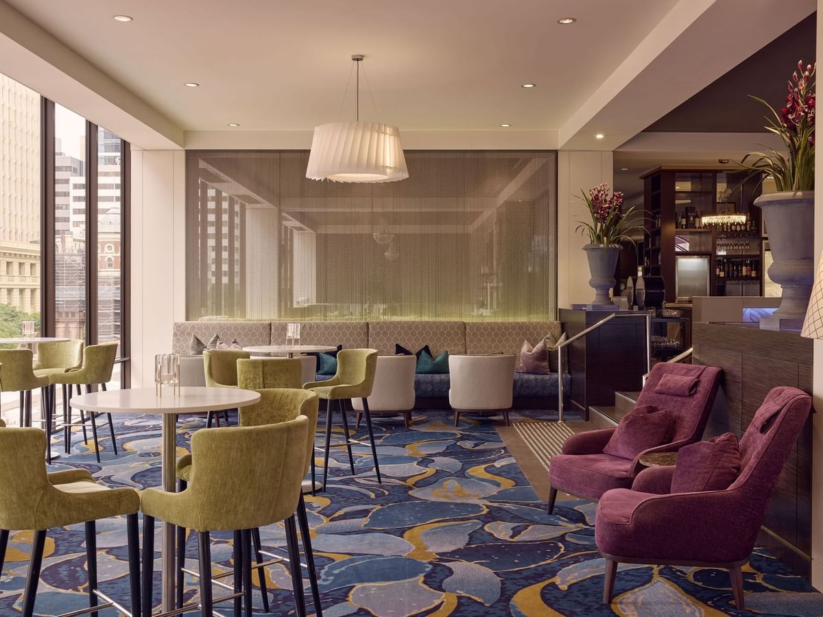 Restaurant Cuvée with stylish chairs and large window overlooking a historic clock tower near Sofitel Brisbane Central