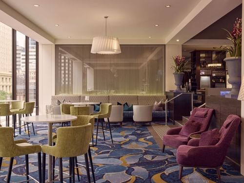 Restaurant Cuvée with stylish chairs and large window overlooking a historic clock tower near Sofitel Brisbane Central