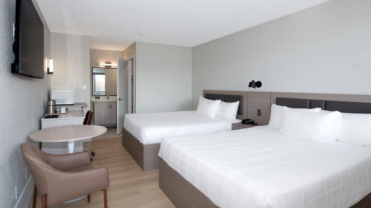 Guest room at Coast Red Deer Hotel with two queen beds and seating area