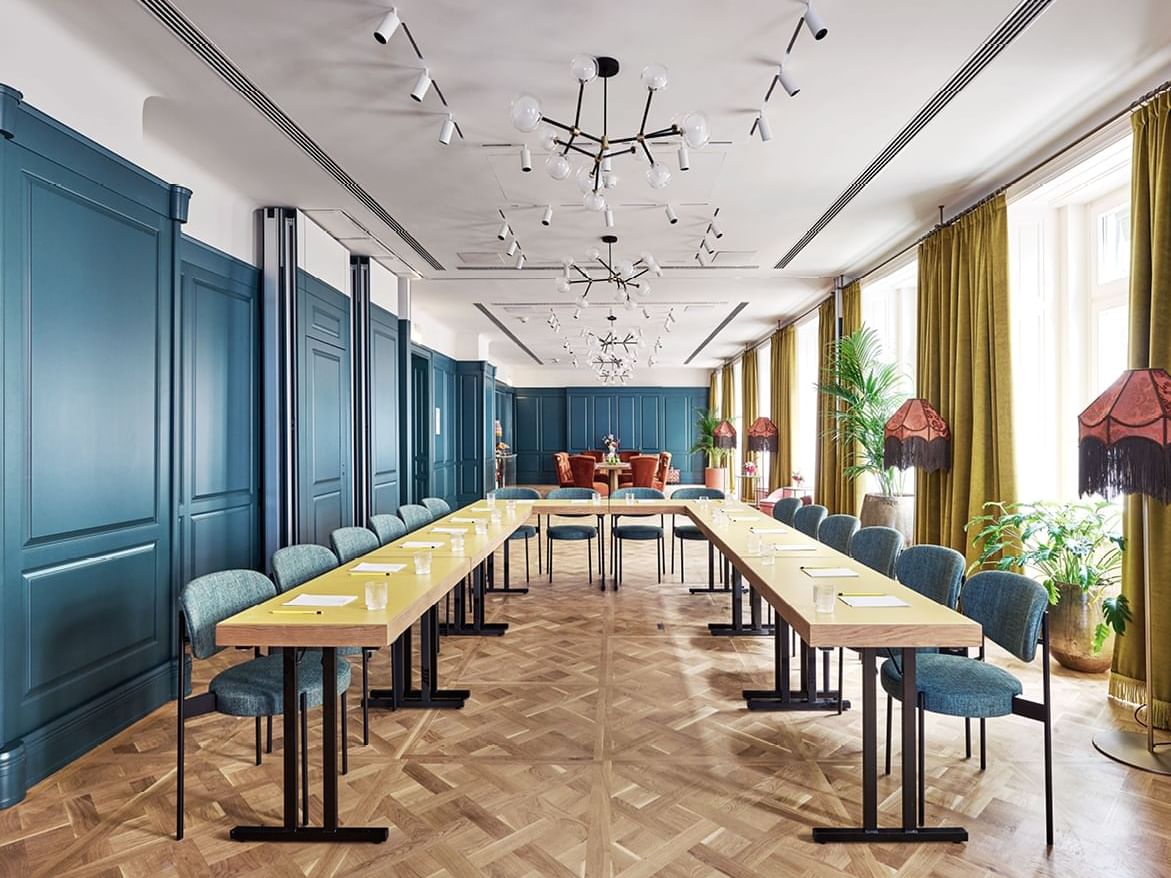 Moderner Konferenzraum mit Holztischen und Stühlen im Hotel Motto in Wien.