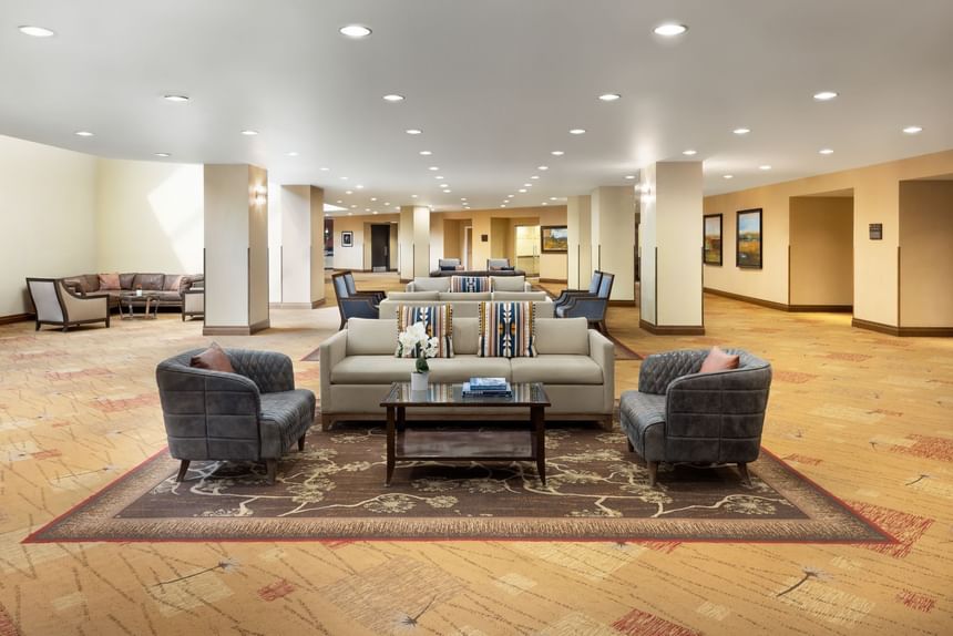 Lounge area with couches, chairs, and a coffee table on a patterned carpet at Elevation Resort Spa