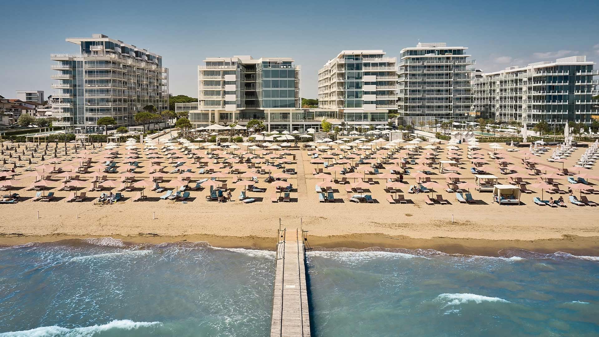 Luftaufnahme des Hotelstrands mit Liegen und Sonnenschirmen bei Falkensteiner Hotel & Spa Jesolo