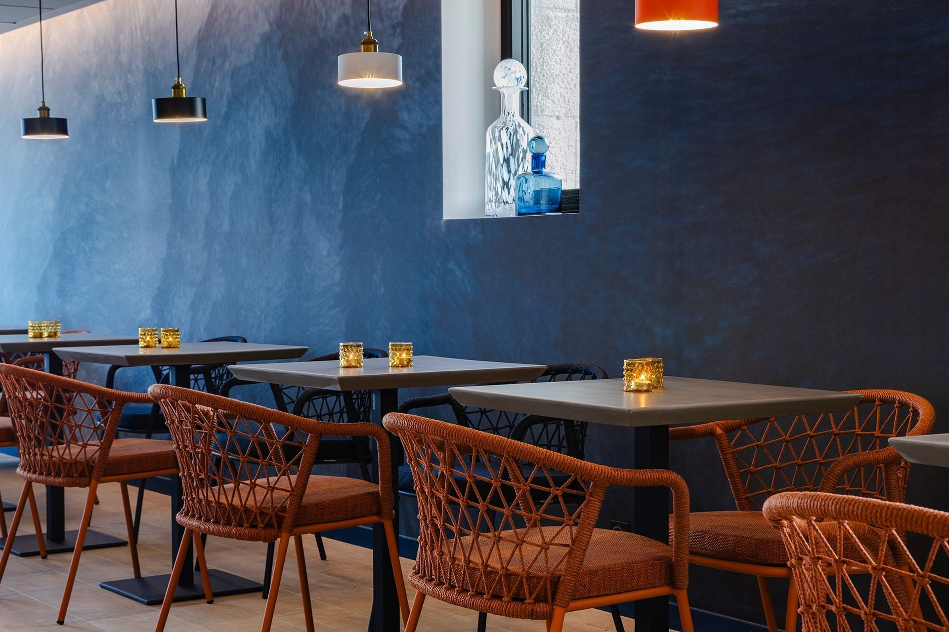 Table dressée à côté d'un canapé bleu dans un restaurant à l'Oceania Saint-Malo