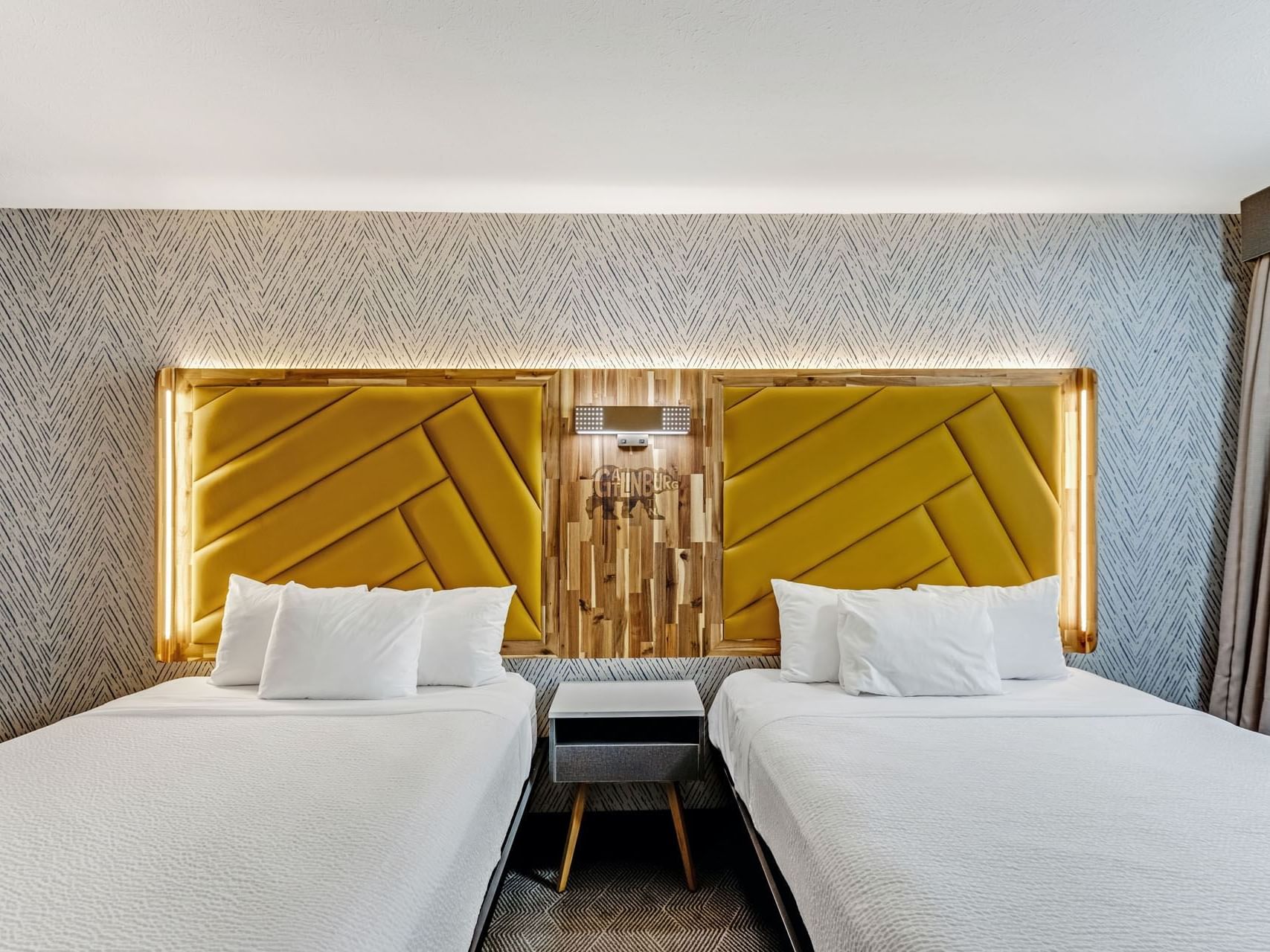 Beds with a nightstand in 2 Queen Deluxe ADA Roll-in Shower  at the Wander Hotel