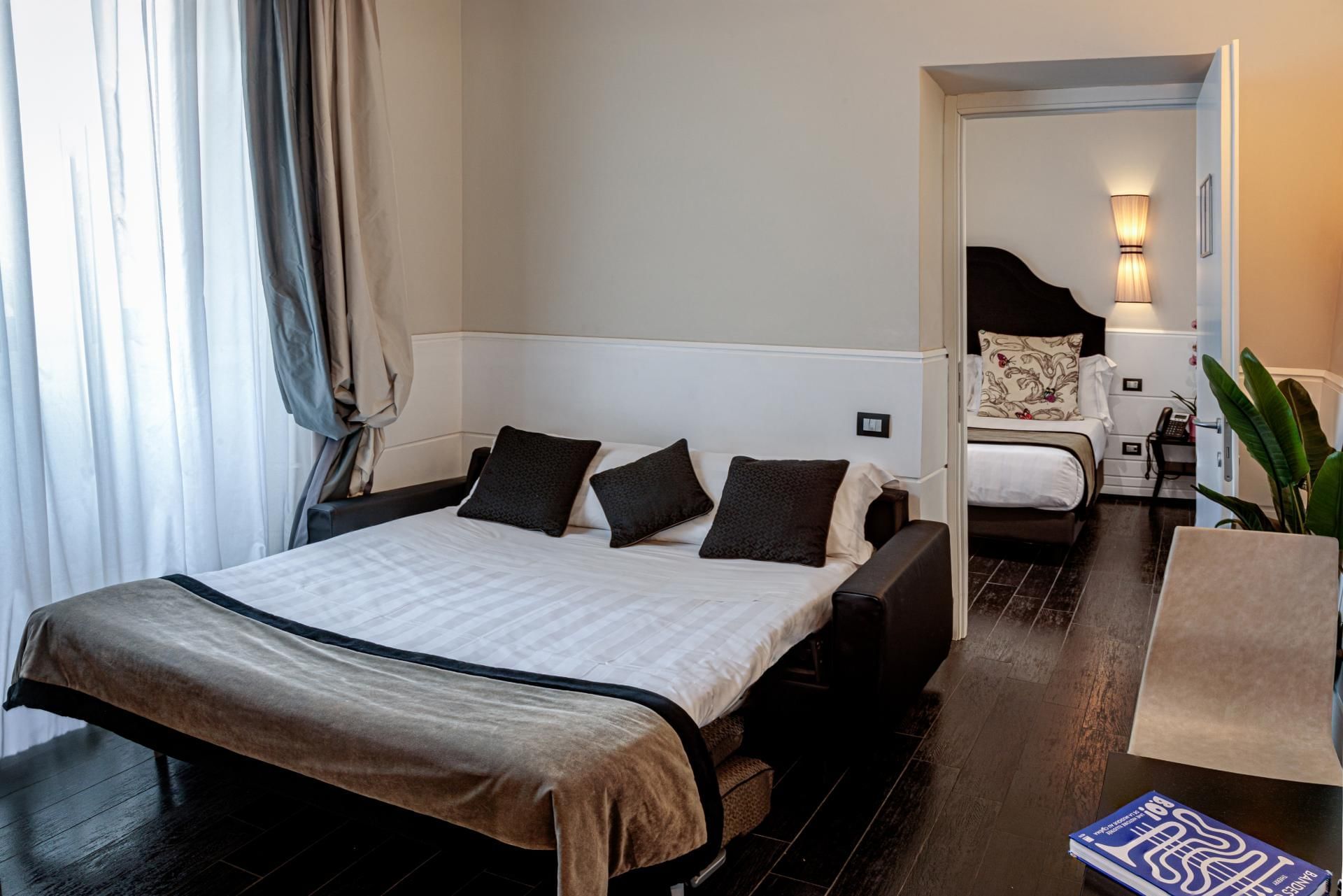 Cozy Family Room at The Independent Suites featuring a double bed, warm decor, and an open door leading to a bedroom