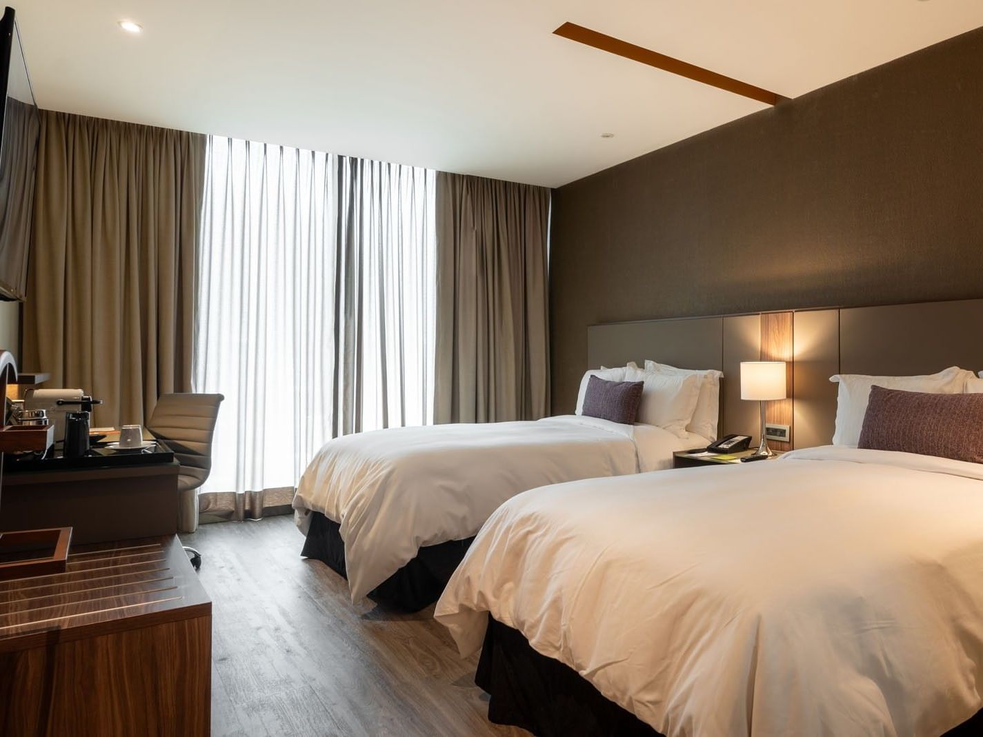 2 Double Deluxe pillows, a desk with a chair, and a window with curtains in a room at Camino Real