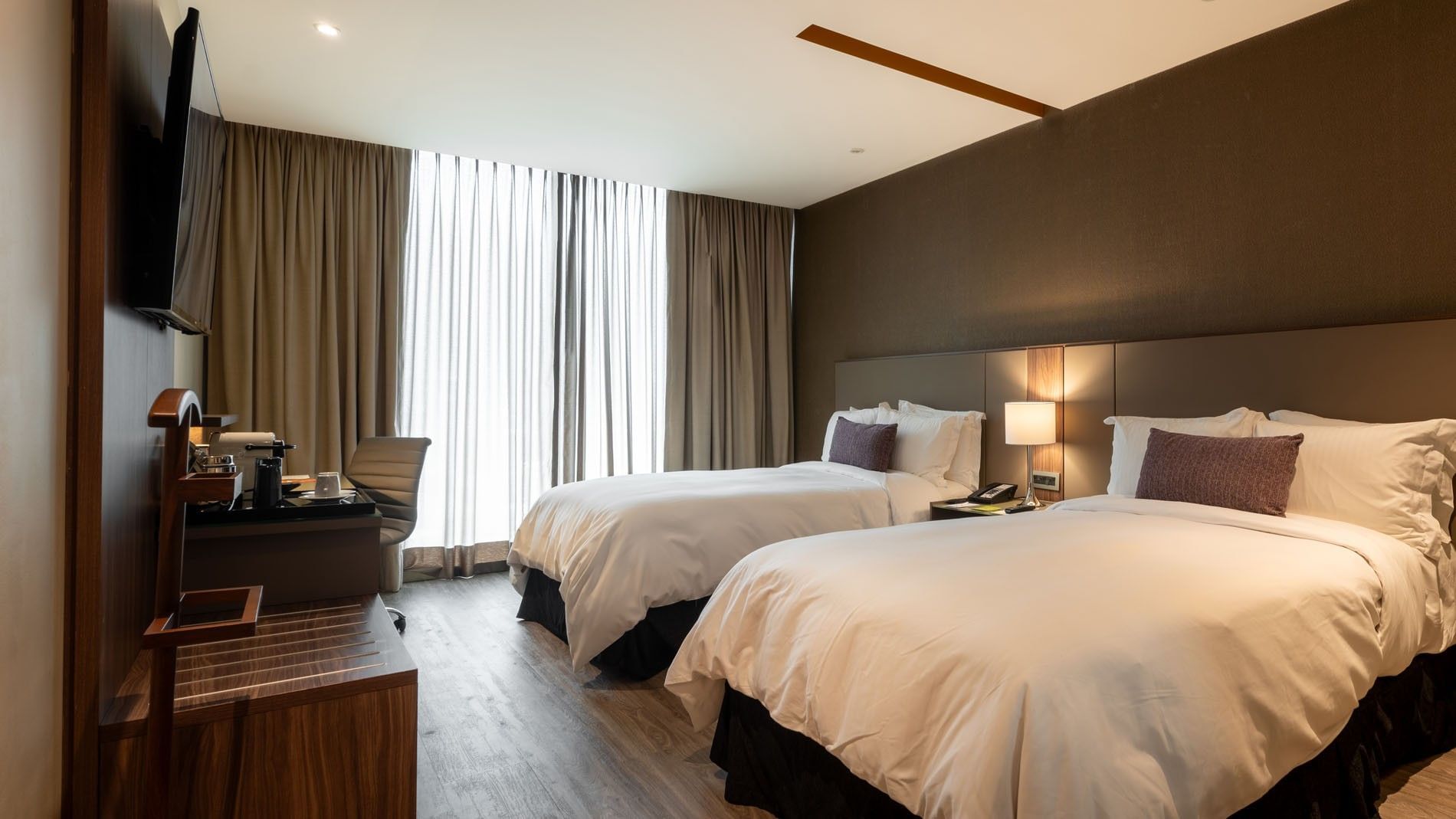 2 Double Deluxe pillows, a desk with a chair, and a window with curtains in a room at Camino Real