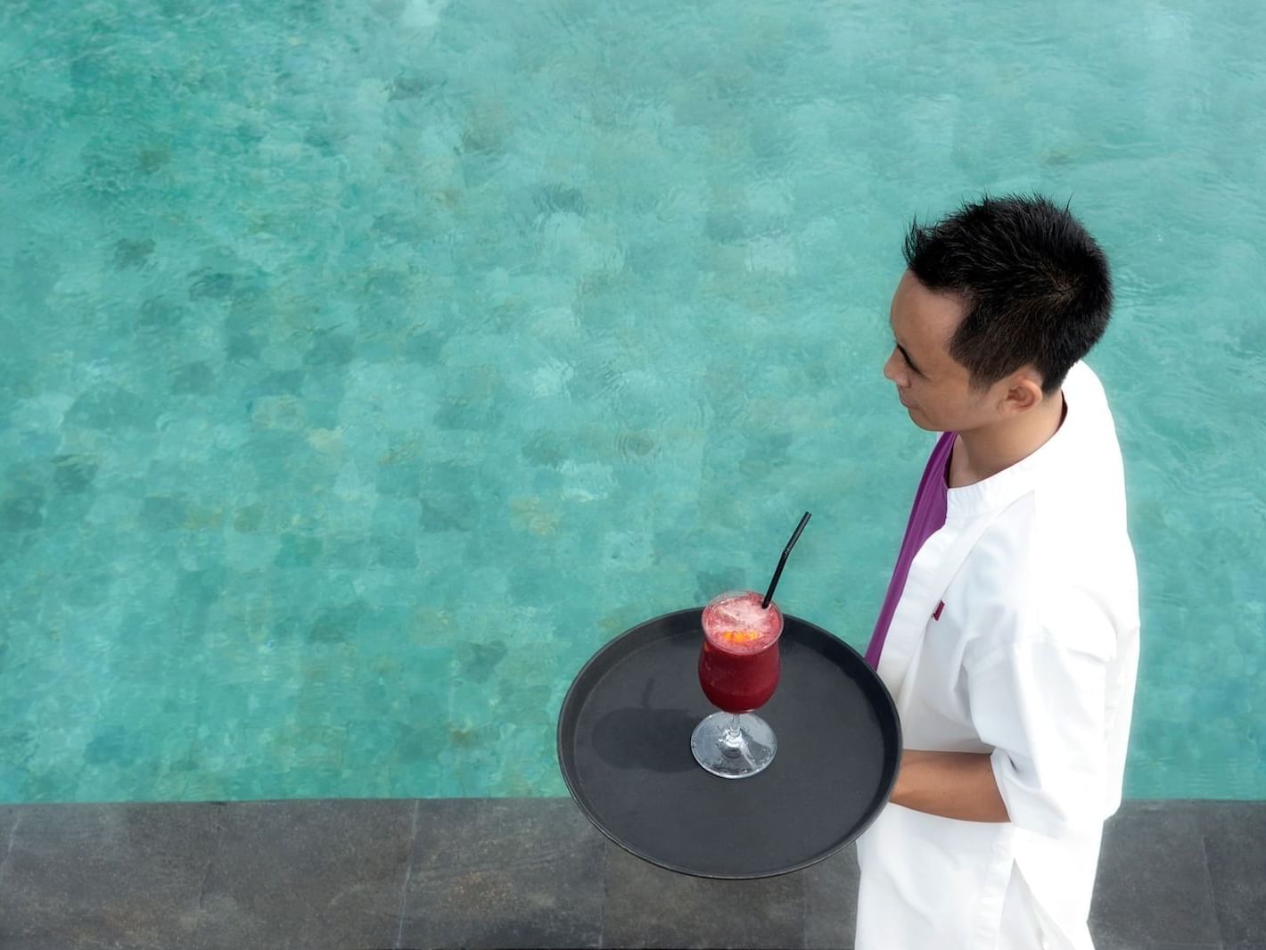 Waiter serving drink in Rooftop Pool Bar at U Hotels & Resorts
