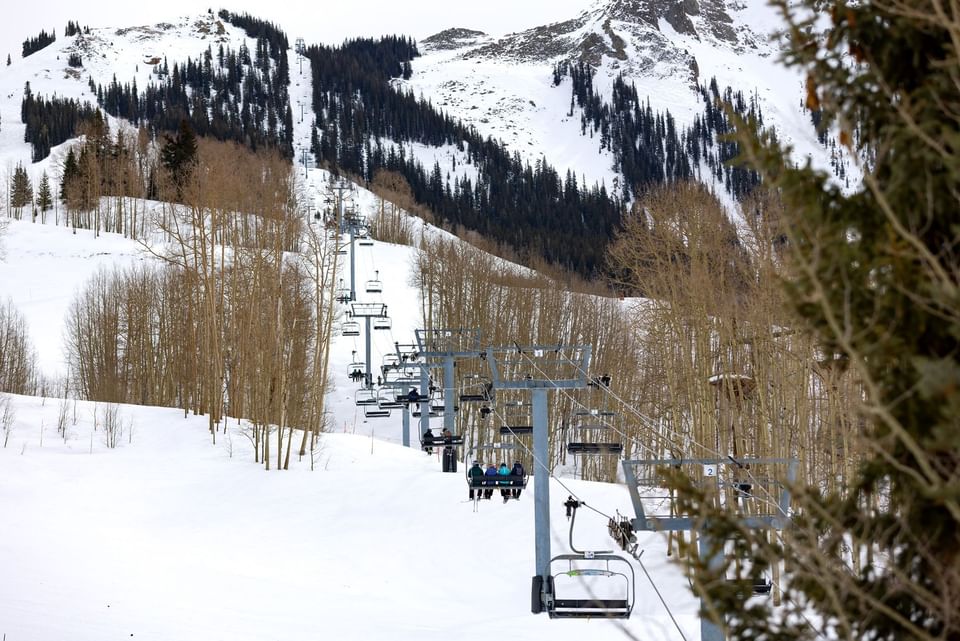Skiers riding a chairlift on a snowy mountain at Elevation Resort Spa