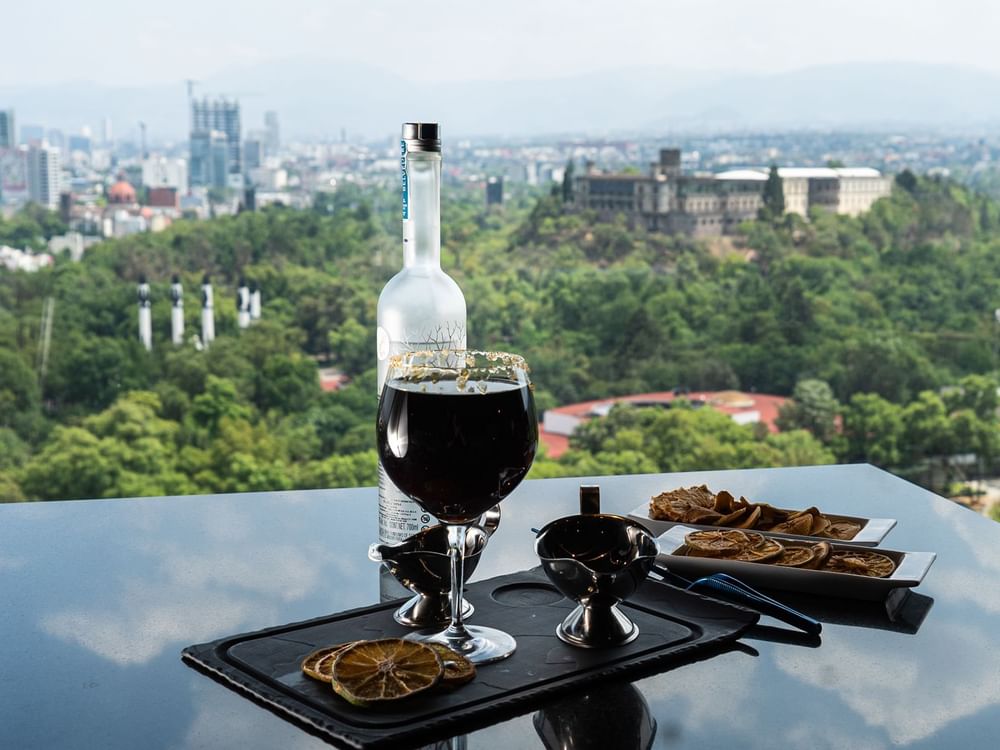 Bottle and glass of wine served with food on a table at Grand Fiesta Americana