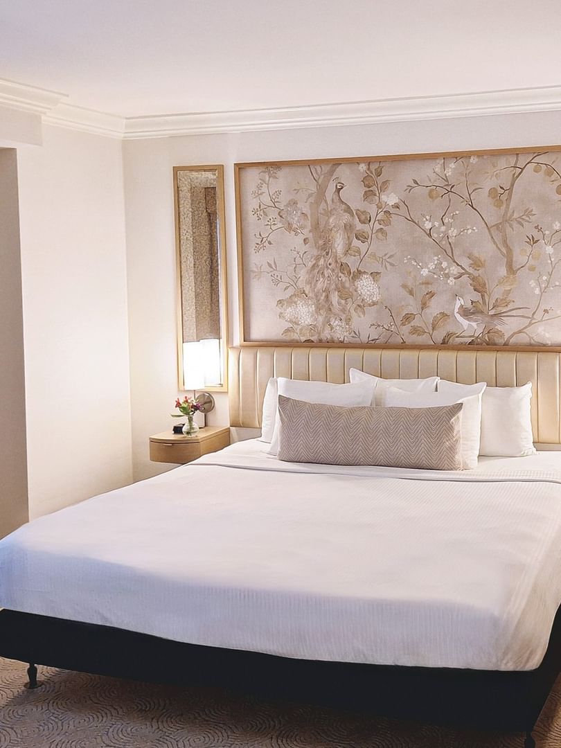Bed with side tables under hanging wall art in Accessible Standard Room at Warwick Allerton Chicago