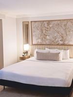 Bed with side tables under hanging wall art in Accessible Standard Room at Warwick Allerton Chicago
