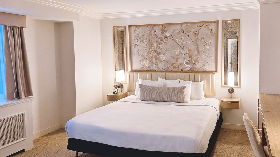 Bed with side tables under hanging wall art in Accessible Standard Room at Warwick Allerton Chicago