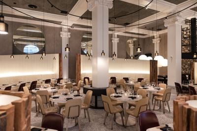 Peter Street Kitchen interior with pendant lighting,white columns and dining tables set up.