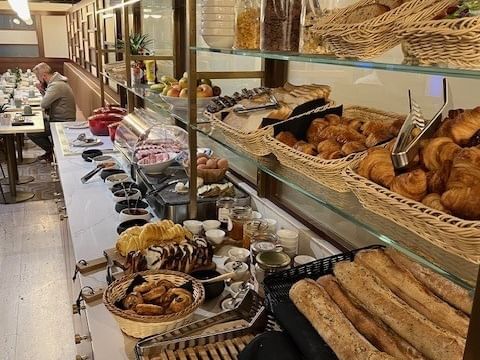 Variété de pains et viennoiseries sur un buffet à Hôtel Le Yachtman.