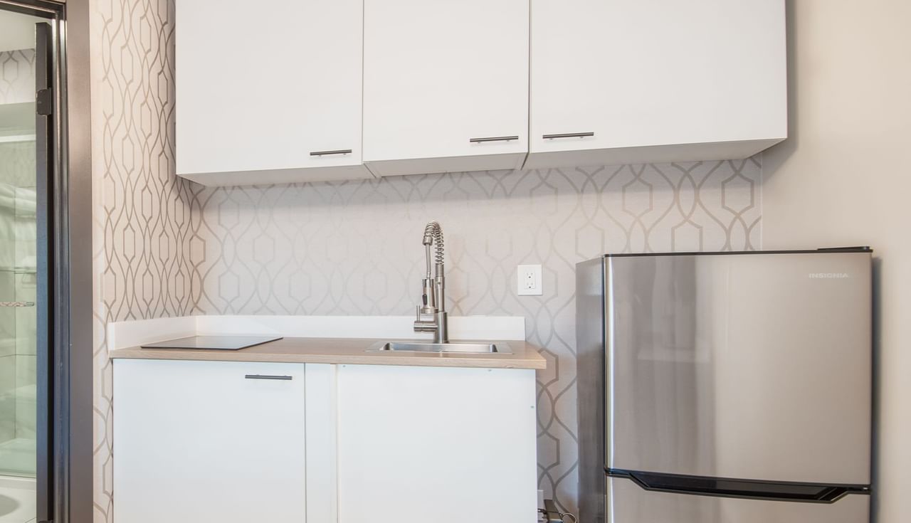Kitchen with fridge, sink and cupboard