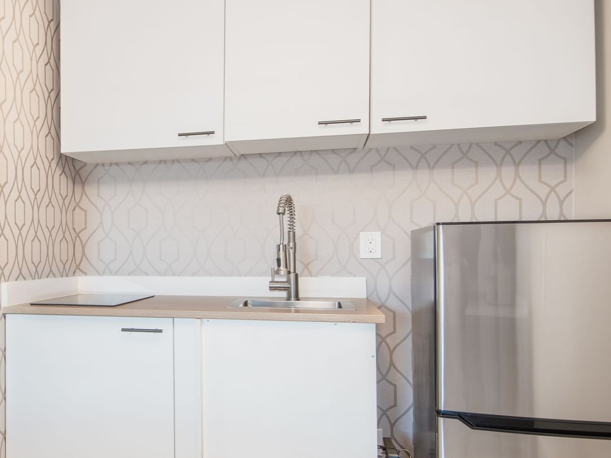 Kitchenette with fridge, sink, and cupboard