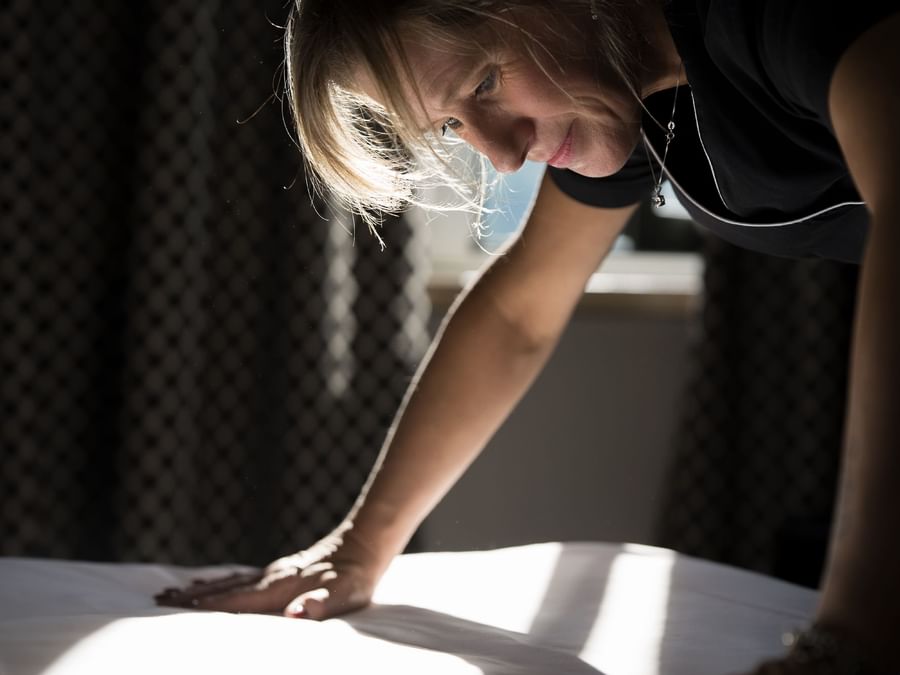 A maid making the bed at Arca Street Art Hotel