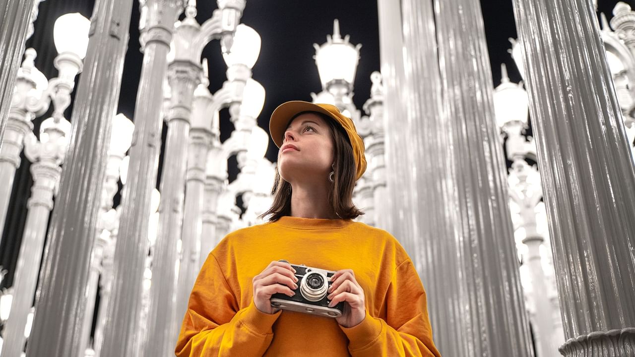 Woman gazing upwards at illuminated street lamps