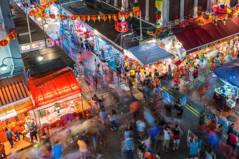 Crowded night market street with lit festive lanterns and food stalls in Chinatown near Grand Park City Hall