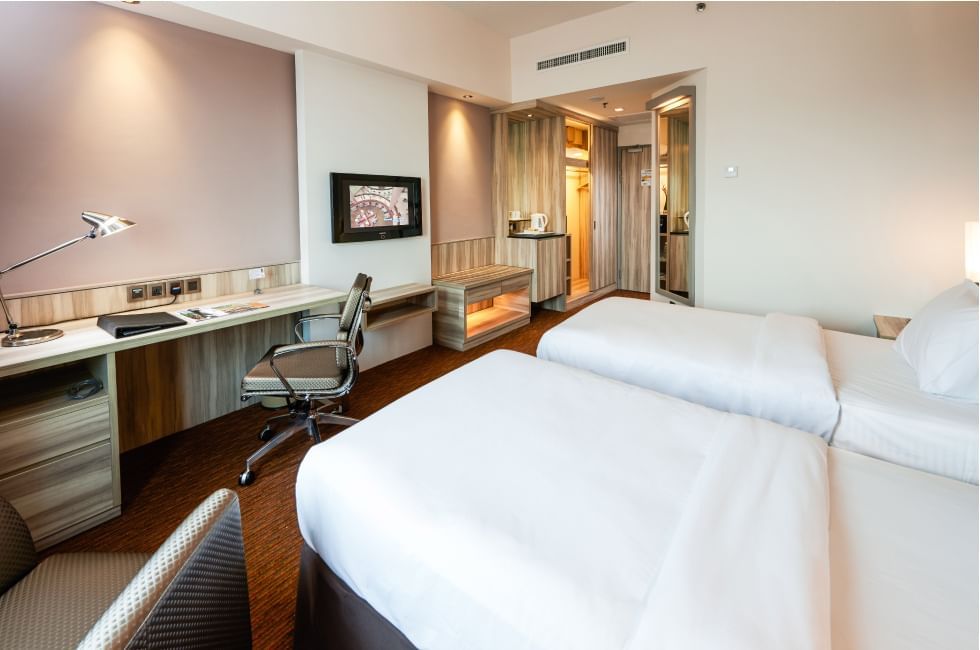 Twin beds with a work desk and a TV in Deluxe Twin Room at Sunway Hotel Seberang Jaya