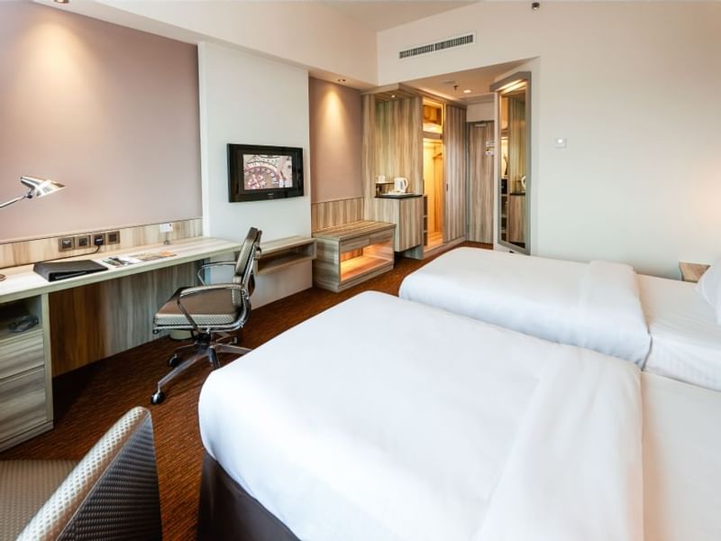 Twin beds with lampshades & a work area in Deluxe Twin Room at Sunway Hotel Georgetown