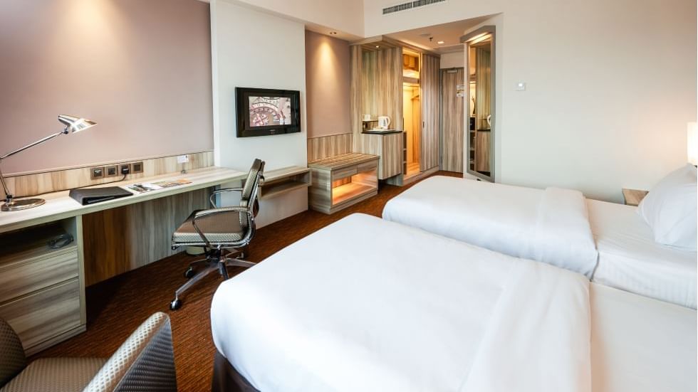 Twin beds with lampshades & a work area in Deluxe Twin Room at Sunway Hotel Georgetown
