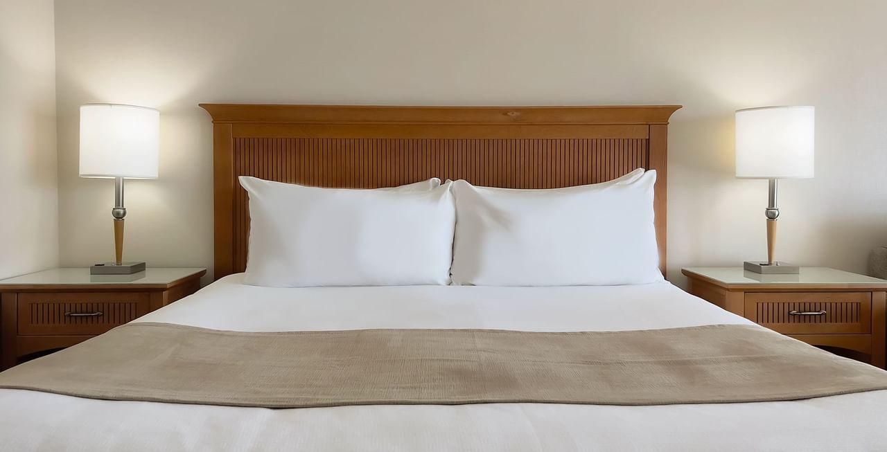 Hotel room with King bed, lamps, and nightstands.