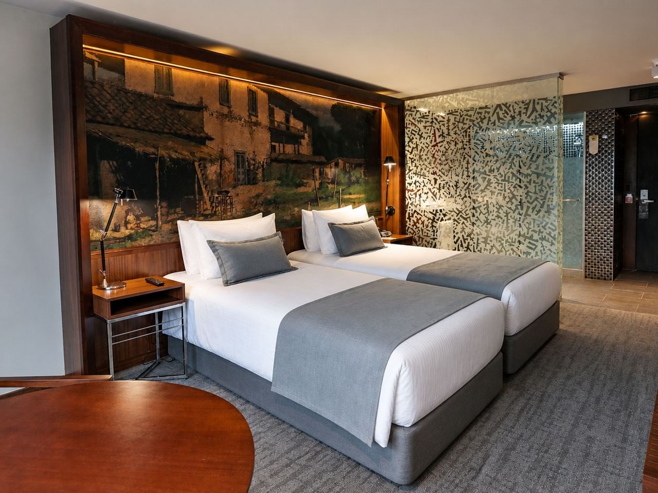 Quarto Duplo Superior Twin com duas camas, arte urbana e banheiro de vidro no Cumbres Lastarria em Santiago