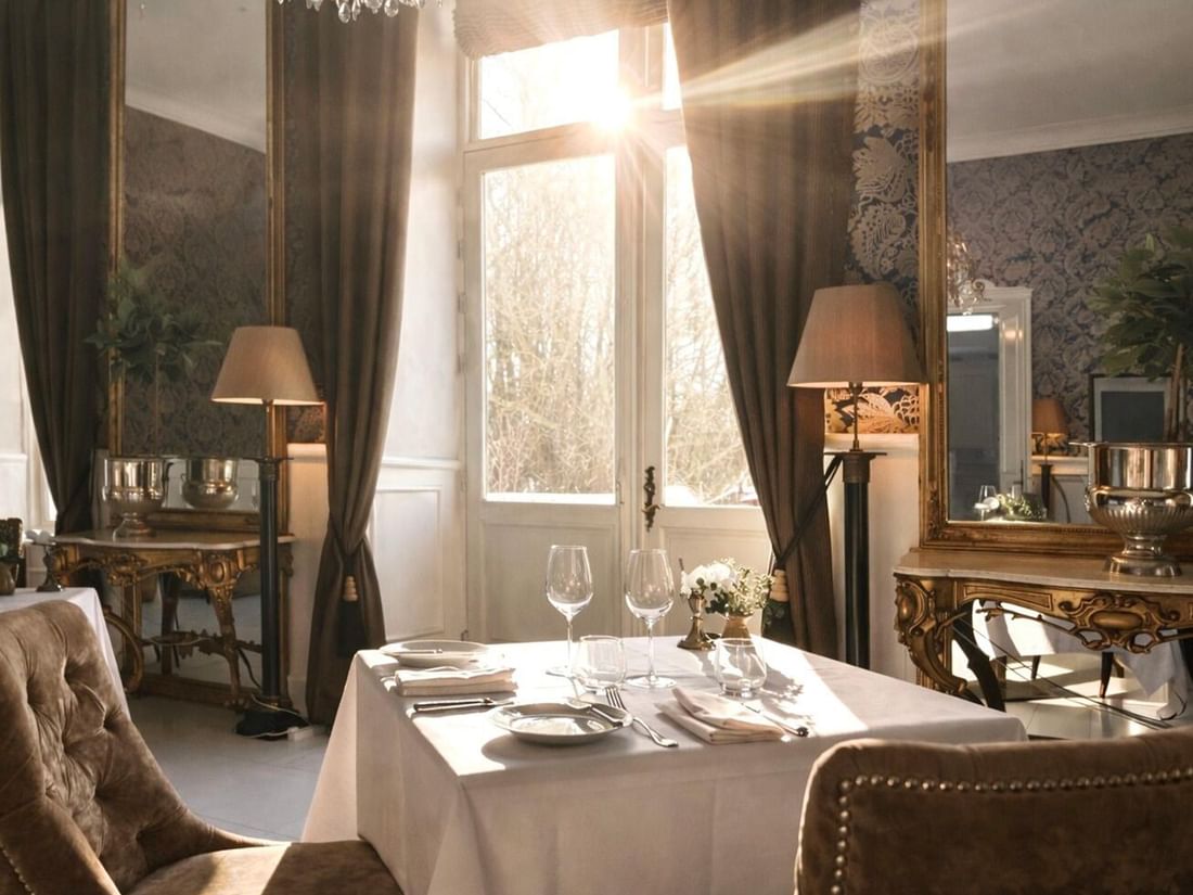 Elegantly set dining table with wine glasses and cutlery in The Terrace at Kokkedal Slot Copenhagen by Warwick, Horsholm.