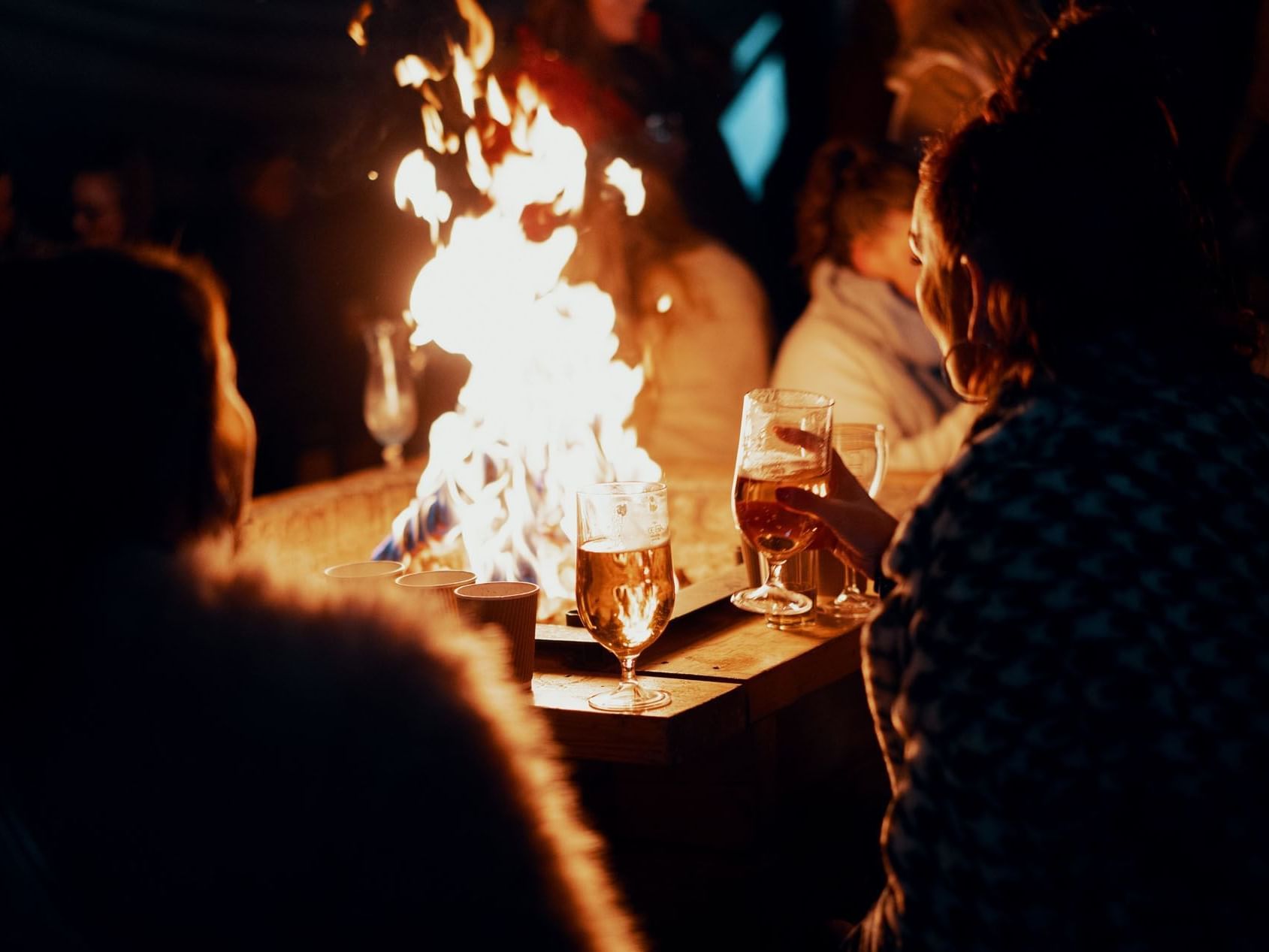 People drinking around the gas firepit at Pelham on Earle
