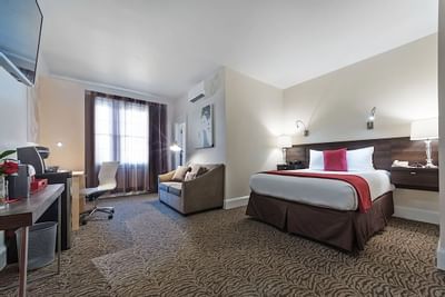 A couch and bed in Guest Room at Artmore Hotel