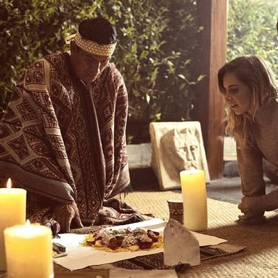 A priest and a woman performing rituals at Hotel Sumaq