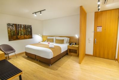 A room with one king bed and other room amenities